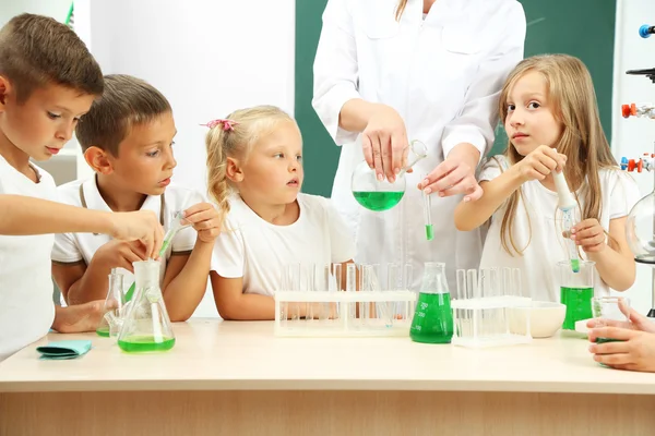 Cute pupils with teacher doing biochemistry research in chemistry class