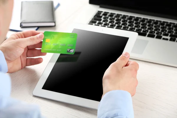 Man holding credit card and tablet