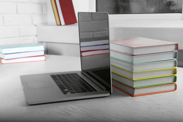 Stack of books with laptop