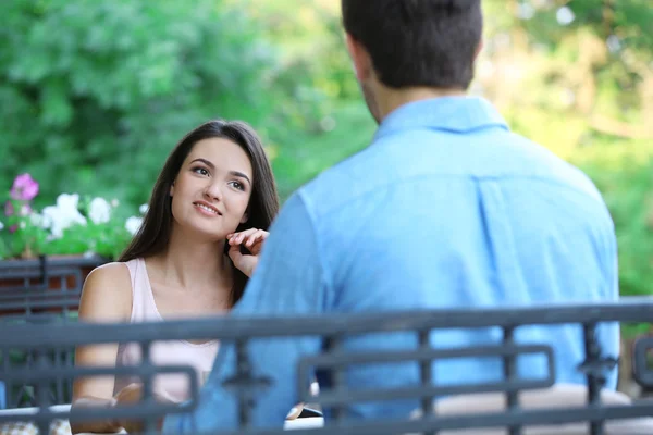 Young woman and man in street cafe