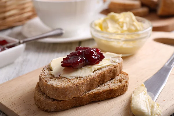 Fresh toast with butter and jam on table close up