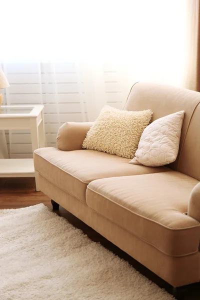 Creamy cozy sofa in the room
