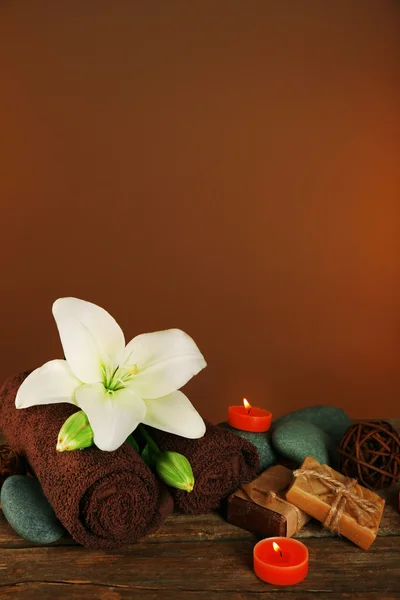 Beautiful spa composition with lily on brown background