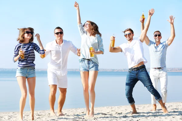 Young people with beer on the riverside