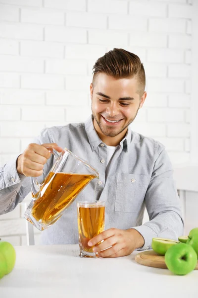 Man pouring apple juice into glass