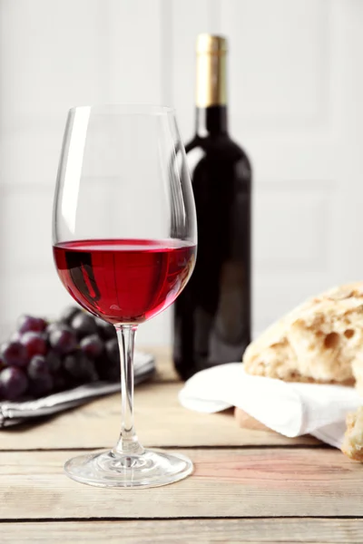 Still life of wine and bread on light background