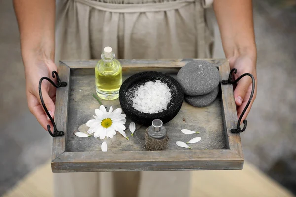 Hands with tray of spa products