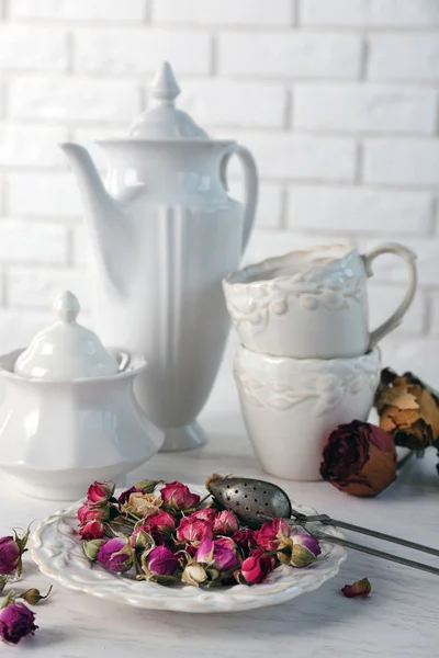 Tea set and tea rose flowers 