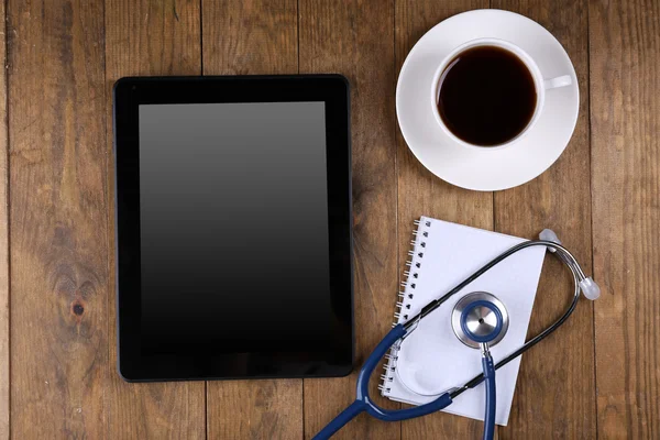 Doctor workplace with blank tablet and stethoscope