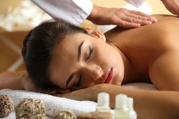 Young woman on massage table in beauty spa salon