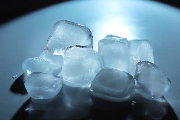 White ice cubes under blue light, close up