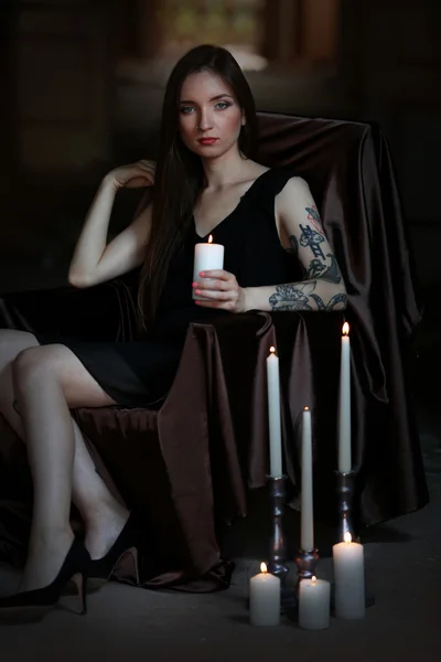 Woman with candle sitting in chair