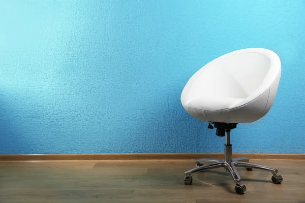 White chair on blue wall background