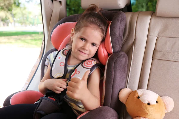 Little girl in the car with teddy bear