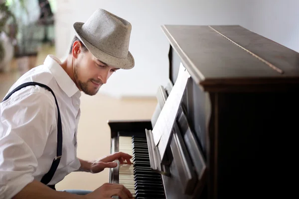 Man in hat making piano music