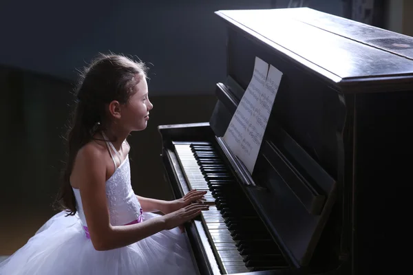 Princess girl plays piano in the studio