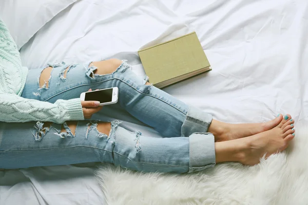 Woman in blue jeans watching phone