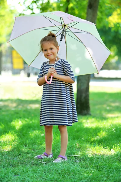 Little girl under big creamy umbrella