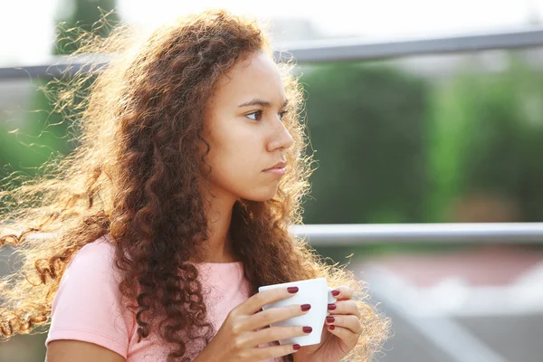 Woman drinking coffee at summer terrace