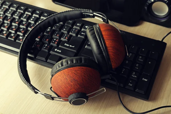 Headphones and keyboard on wooden table