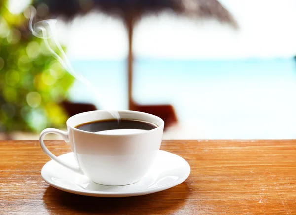 Cup of coffee on sea background