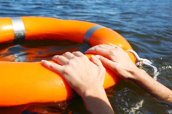 Hands hold a life buoy