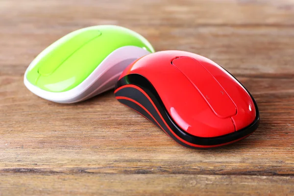 Wireless computer mouses on wooden background