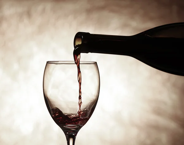 Pouring red wine from bottle into glass