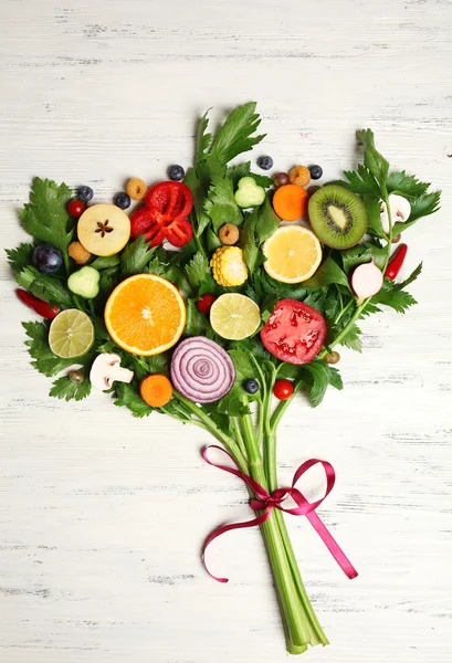 Cute colourful bouquet of sliced vegetables on light wooden background