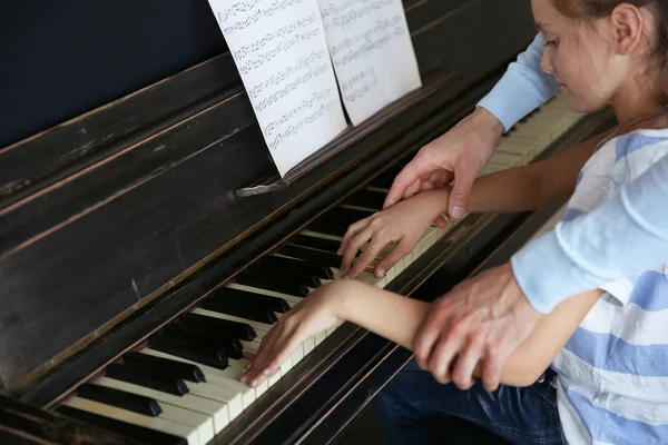 Teacher and girl playing piano