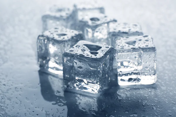 Melting ice cubes with drops around, close up