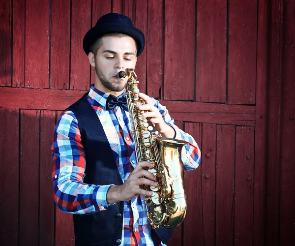 Man in hat plays music on sax