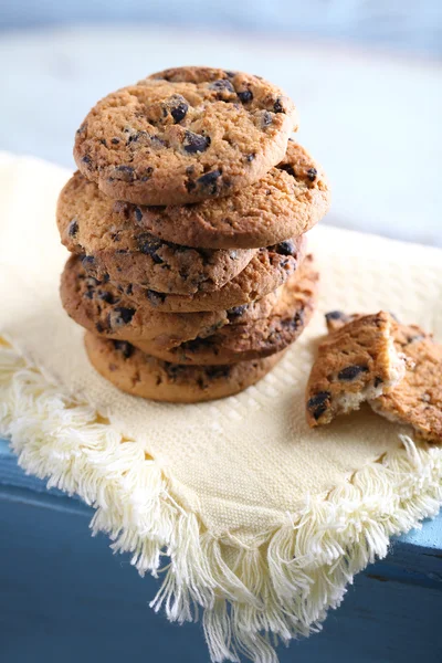 Cookies with chocolate crumbs on white napkin against blurred background, close up