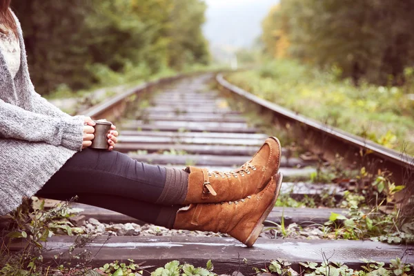 Woman sitting on rail track