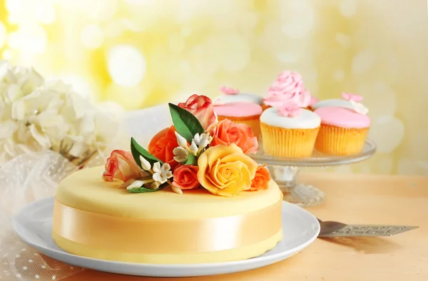 Cake with sugar paste flowers, on light background