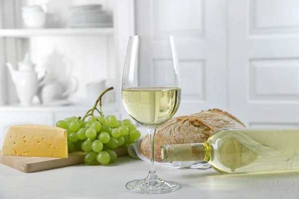 Still life of wine, grape, cheese and bread on light background