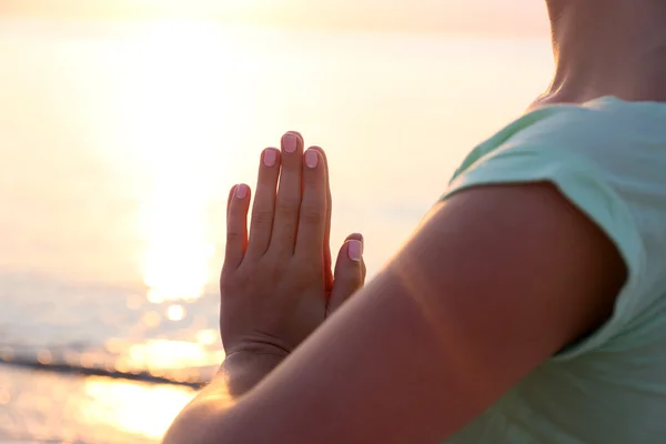 Young beautiful woman meditating yoga on the beach, close up