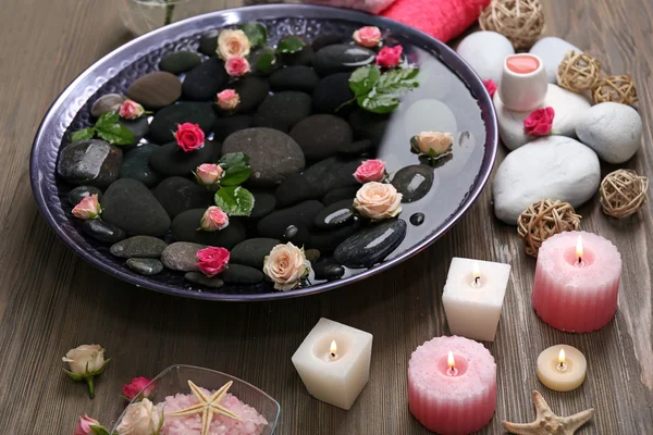 Spa composition of candles, flowers and stones in water