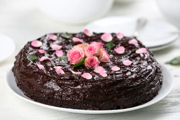 Chocolate cake decorated with flowers on the table