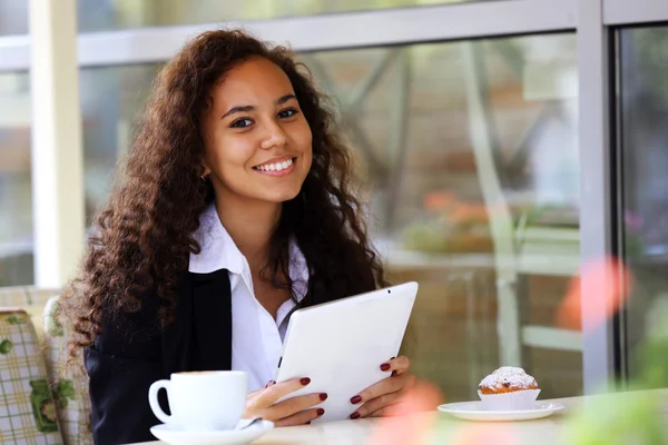 Beautiful business woman with white tablet in the restaurant