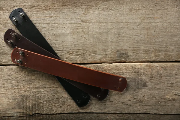 Leather bracelets on wooden background