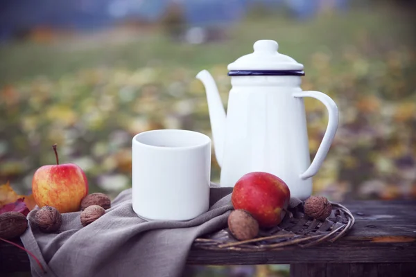 Teapot, fruits and nuts on bench