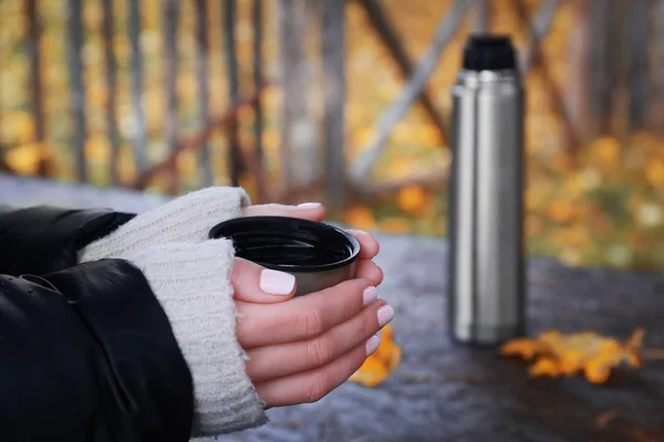 Woman holding thermos cup