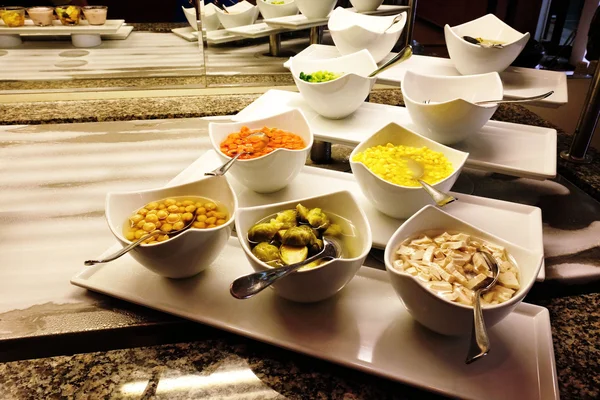 Bowls with garnish on the table in all-inclusive restaurant