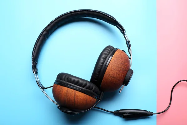 Black and brown headphones on pink-blue background