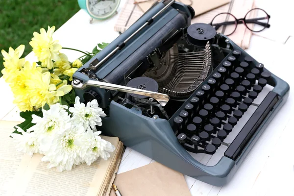 Vintage black typewriter with papers and flowers