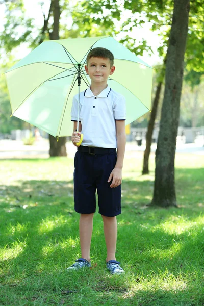 Boy under big creamy umbrella