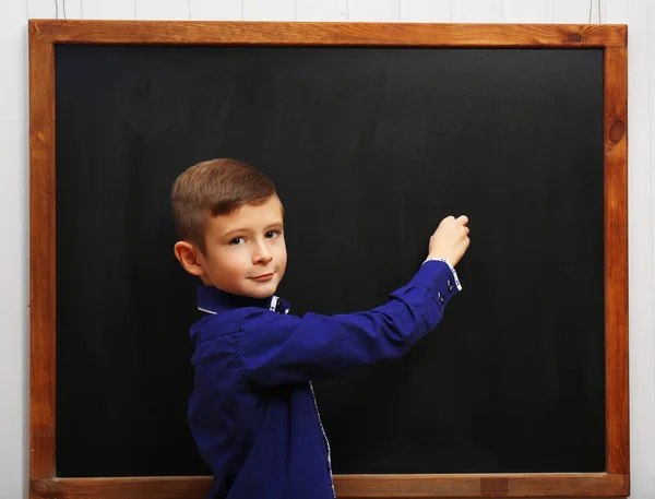 Boy posing at the clean blackboard