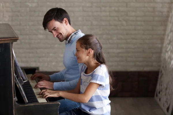 Teacher and girl playing piano