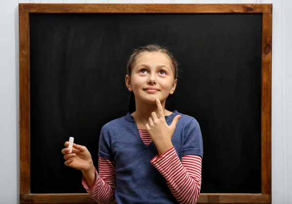 Girl posing at clean blackboard
